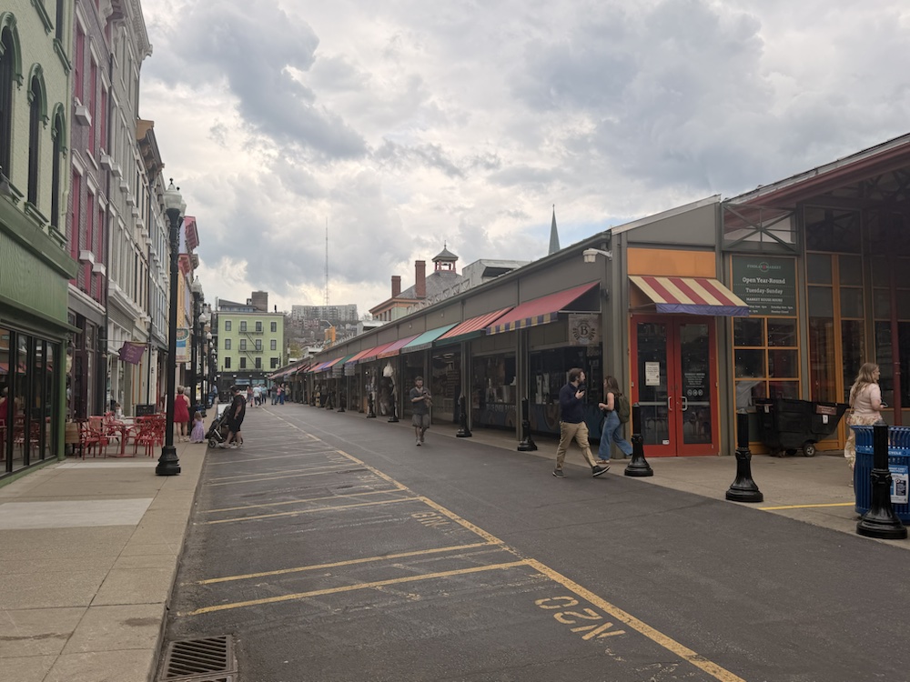 A long view down the Findlay Market sheds under striped awnings.