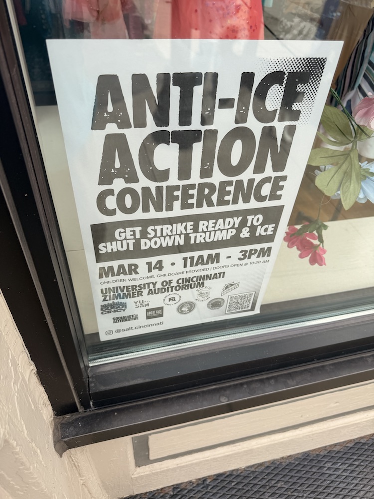 An Anti-ICE Action Conference poster taped inside a window near Findlay Market.