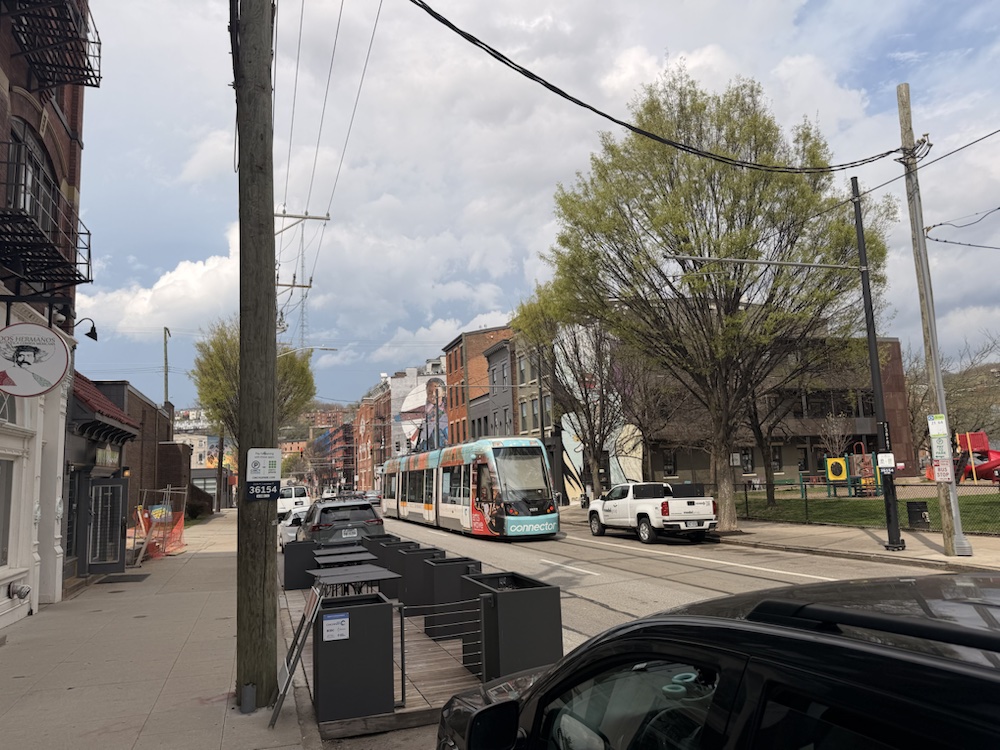 A Cincinnati streetcar moving past Findlay Market and nearby buildings.