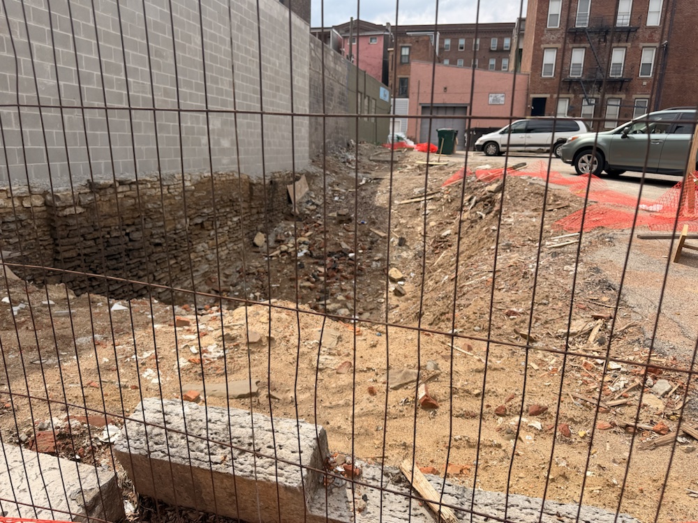An excavation lot behind a construction fence near Findlay Market.